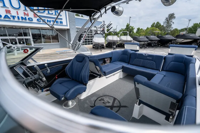 Slide: The Image of 2021 MasterCraft X24 boat interior with blue seating at a dealership. - 42