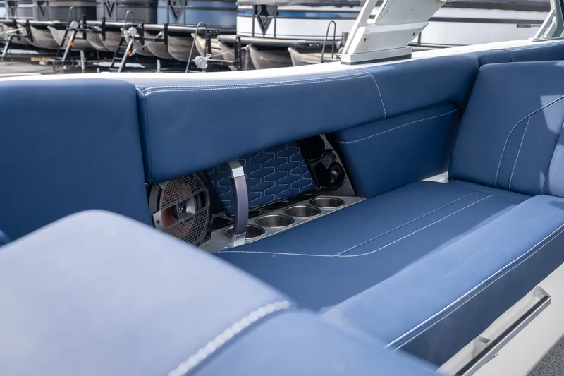 Slide: The Image of 2021 MasterCraft X24 boat interior with blue seating and cup holders. - 24