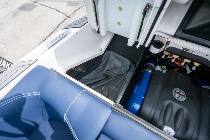Slide: The Image of 2021 MasterCraft X24 engine compartment with blue upholstery and storage area. - 52