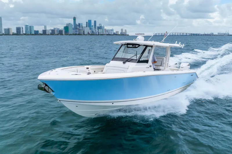 Slide: The Image of 2025 Pursuit S 328 Sport boat cruising on ocean near city skyline. - 1