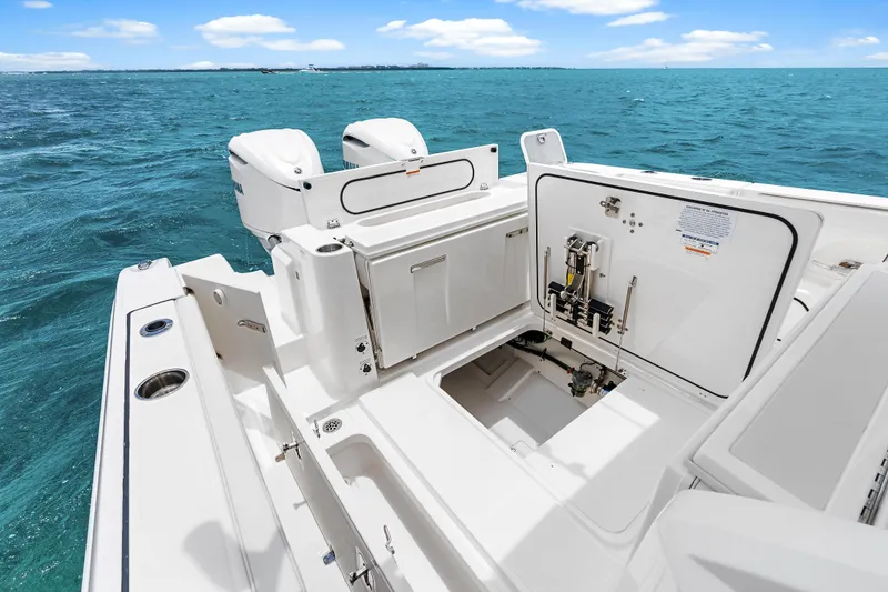 Slide: The Image of 2025 Pursuit S 328 Sport boat with open storage compartments on a sunny ocean day. - 33