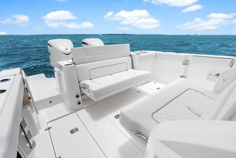 Slide: The Image of 2025 Pursuit S 328 Sport boat interior with white seating, ocean view, and clear sky. - 31