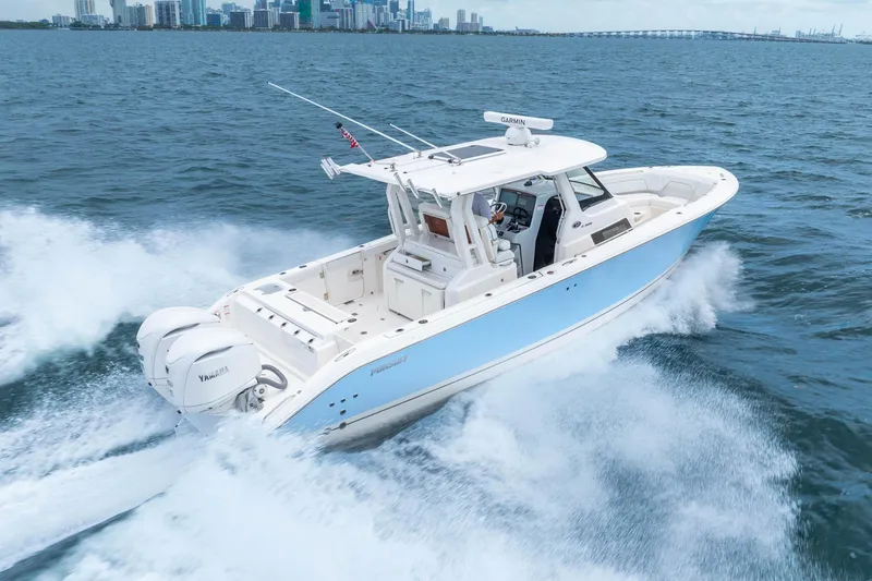 Slide: The Image of 2025 Pursuit S 328 Sport boat cruising on open water near city skyline. - 7