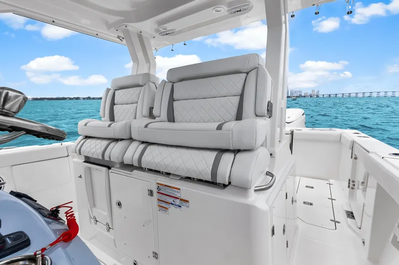 Slide: The Image of 2025 Pursuit S 328 Sport boat interior with luxurious seating, ocean view, and clear skies. - 20