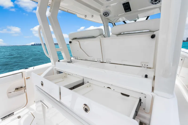 Slide: The Image of 2025 Pursuit S 328 Sport boat interior with open storage drawers, ocean view. - 27