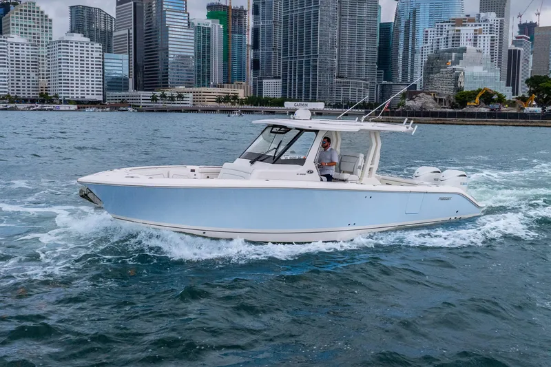 Slide: The Image of 2025 Pursuit S 328 Sport boat cruising near city skyline on a sunny day. - 3