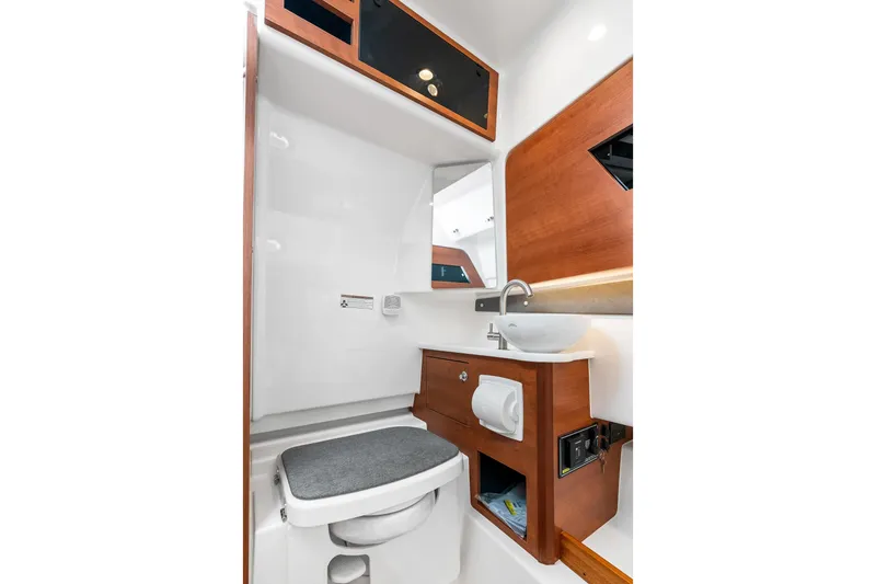 Slide: The Image of 2025 Pursuit S 328 Sport boat interior bathroom with modern sink and wooden cabinetry. - 39