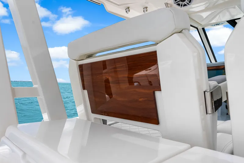 Slide: The Image of 2025 Pursuit S 328 Sport boat interior with white seating and wooden accents. - 26