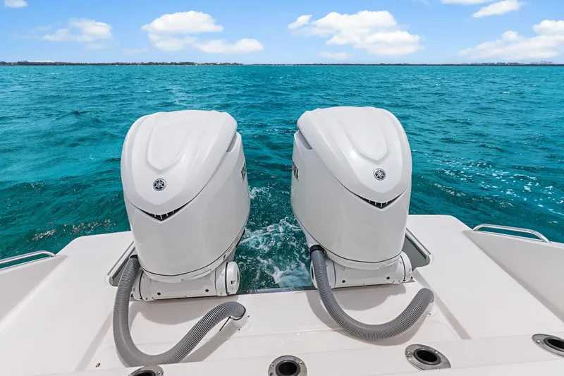 Slide: The Image of 2025 Pursuit S 328 Sport boat with dual outboard engines on turquoise water. - 42