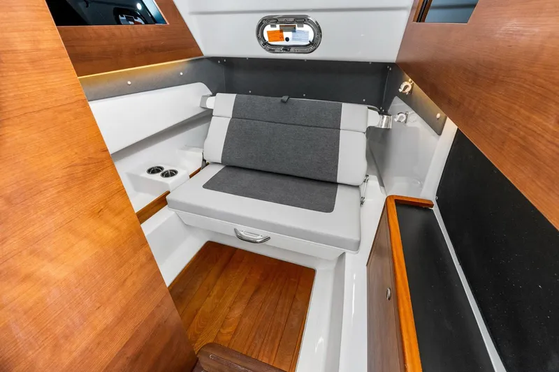Slide: The Image of 2025 Pursuit S 328 Sport cabin interior with wooden accents and gray seating. - 37