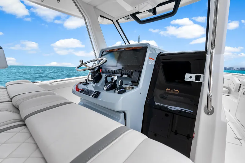 Slide: The Image of 2025 Pursuit S 328 Sport boat interior with modern helm and ocean view. - 22