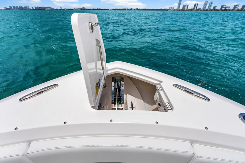 Slide: The Image of 2025 Pursuit S 328 Sport boat with open anchor hatch on blue ocean. - 17
