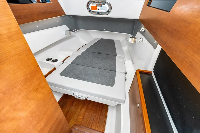Slide: The Image of 2025 Pursuit S 328 Sport cabin interior with wooden accents and comfortable seating. - 36