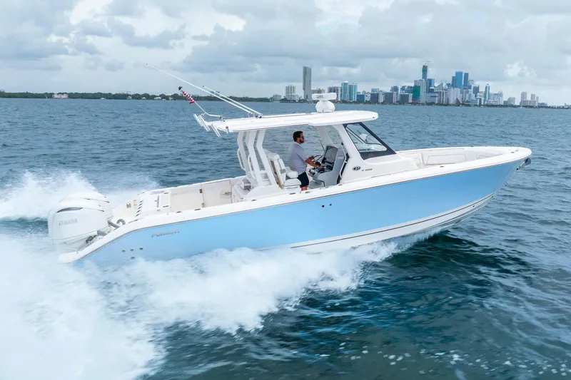 Slide: The Image of 2025 Pursuit S 328 Sport boat cruising on ocean near city skyline. - 6