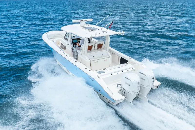 Slide: The Image of 2025 Pursuit S 328 Sport boat cruising on open water with twin engines. - 8