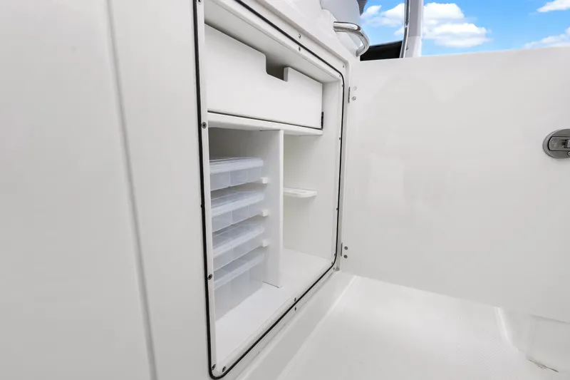 Slide: The Image of 2025 Pursuit S 328 Sport boat storage compartment with organized shelves and drawers. - 28