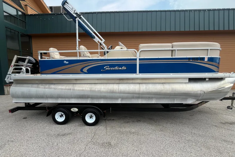 The Image of 2013 Godfrey Sweetwater 2286 FC pontoon boat on trailer, featuring Mercury outboard motor. - 1