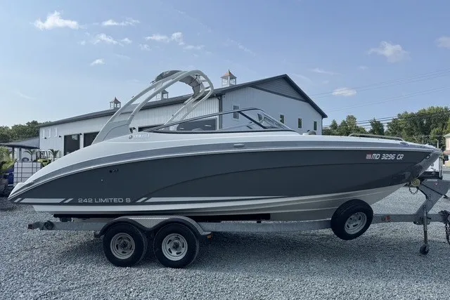 Slide: The Image of 2015 Yamaha Boats 242 Limited S on trailer, parked outdoors near a building. - 2