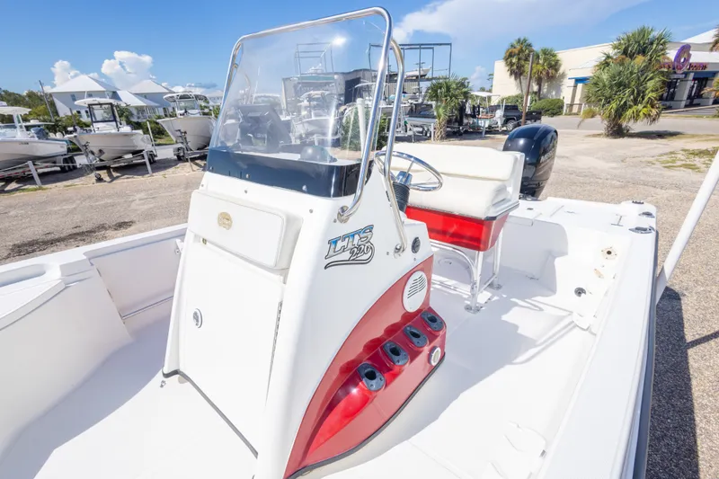 Slide: The Image of 2003 Triton 220 LTS boat with center console and seating, parked outdoors. - 37