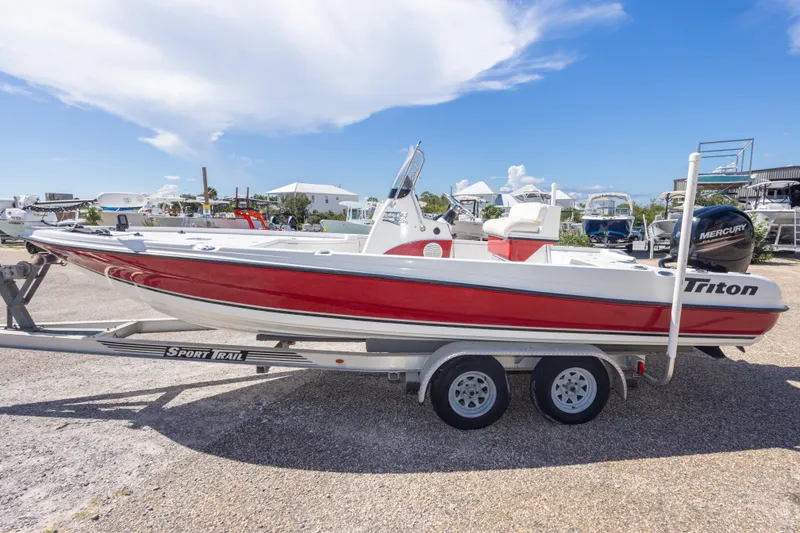 Slide: The Image of 2003 Triton 220 LTS boat on trailer, red and white design, parked outdoors. - 17