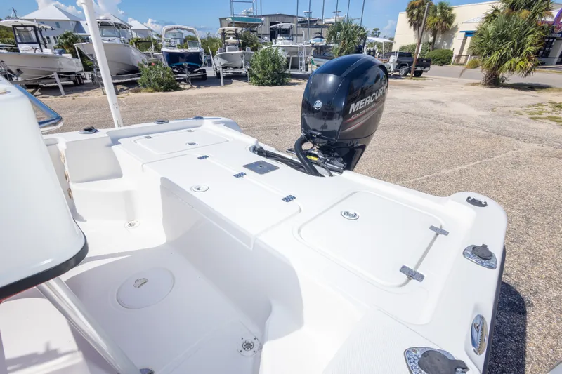 Slide: The Image of 2003 Triton 220 LTS boat with Mercury outboard motor in a marina setting. - 42