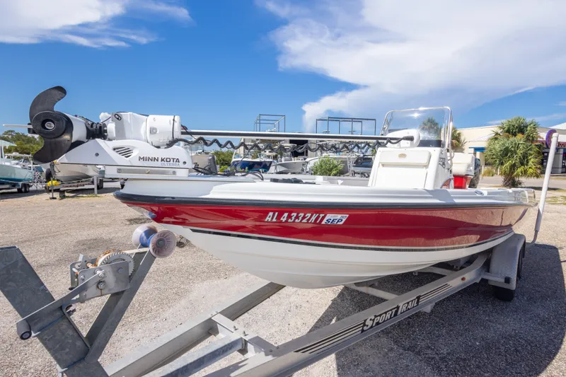 Slide: The Image of 2003 Triton 220 LTS boat on trailer with Minn Kota motor, parked outdoors. - 19