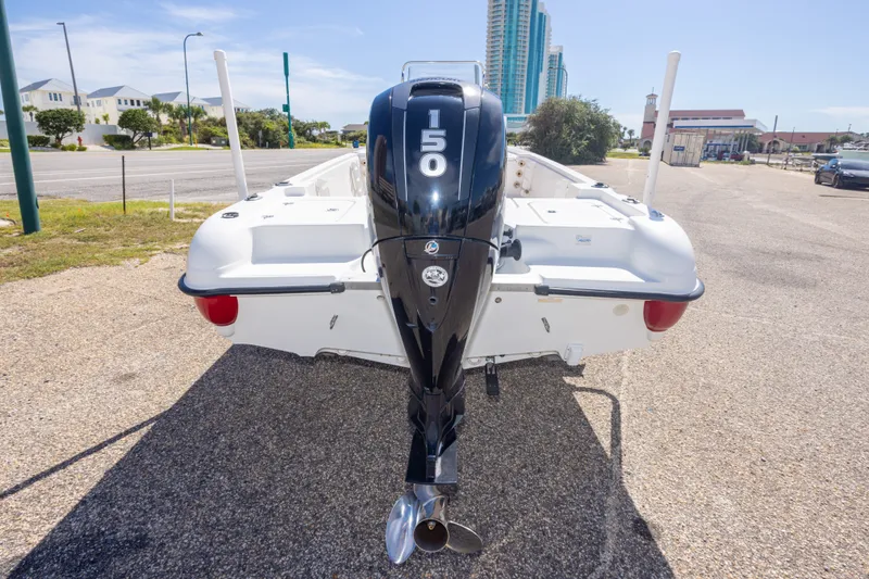 Slide: The Image of 2003 Triton 220 LTS boat with a 150 HP outboard motor, parked on pavement. - 15