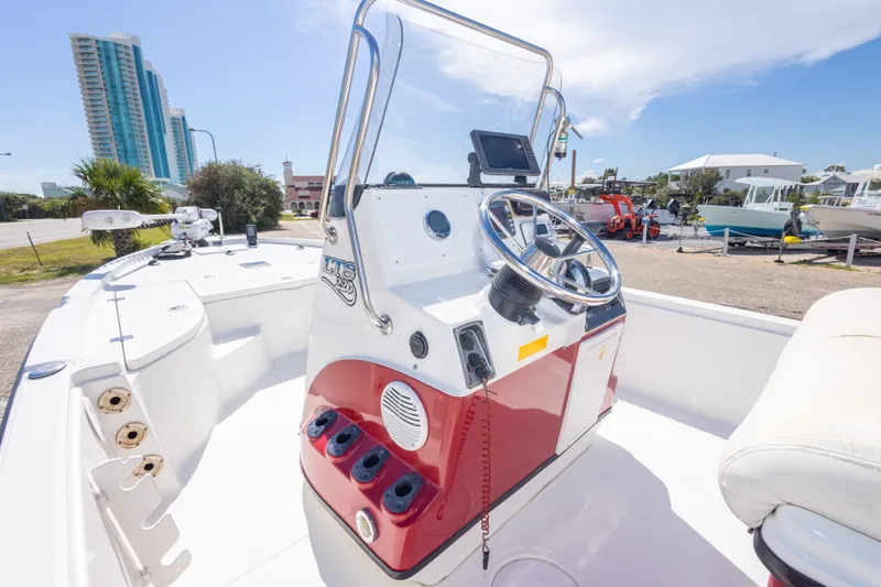 Slide: The Image of 2003 Triton 220 LTS boat with steering console, docked near modern buildings. - 31