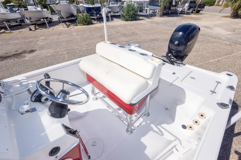 Slide: The Image of 2003 Triton 220 LTS boat interior with steering wheel and seating, parked outdoors. - 38