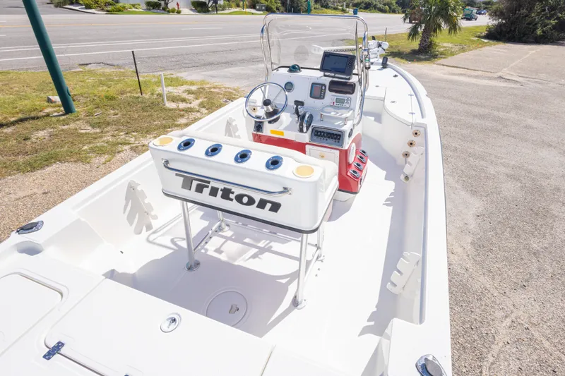 Slide: The Image of 2003 Triton 220 LTS boat with console and seating, parked on roadside. - 24