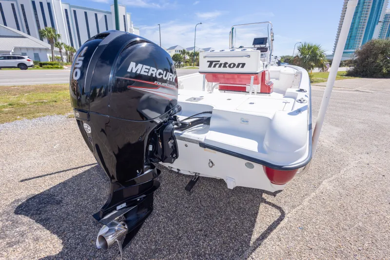 Slide: The Image of 2003 Triton 220 LTS boat with Mercury outboard motor, parked on a sunny day. - 14