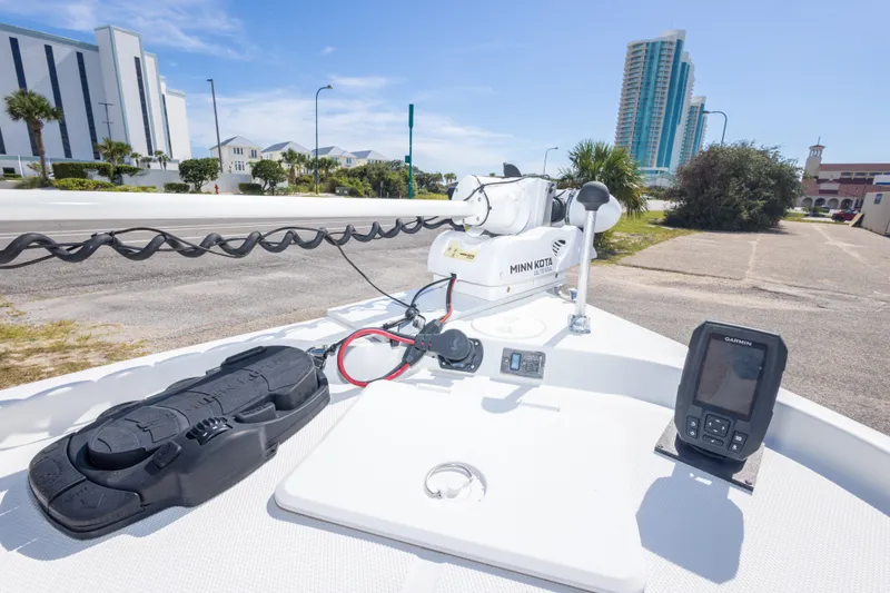 Slide: The Image of 2003 Triton 220 LTS boat with Minn Kota trolling motor and Garmin device, urban backdrop. - 34