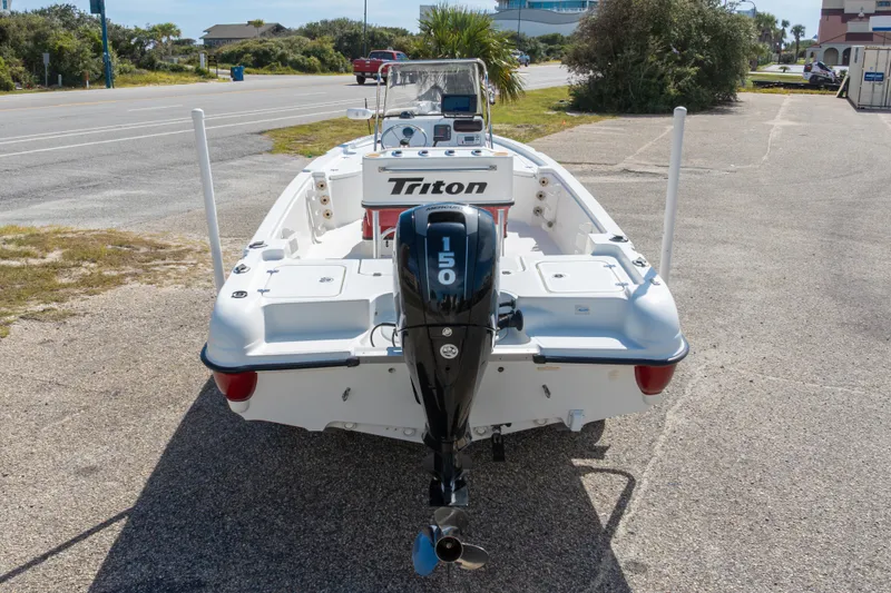 Slide: The Image of 2003 Triton 220 LTS boat with 150 horsepower outboard motor, parked on a sunny street. - 51