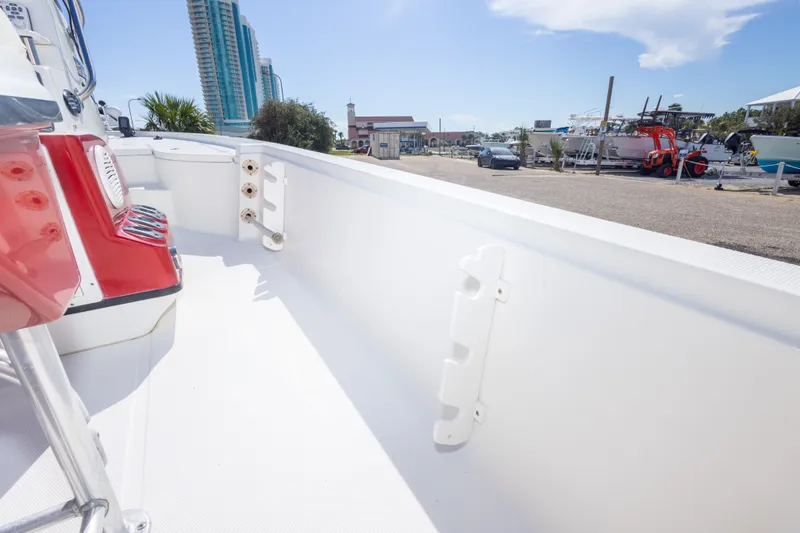 Slide: The Image of 2003 Triton 220 LTS boat interior with red accents, docked near high-rise buildings. - 44
