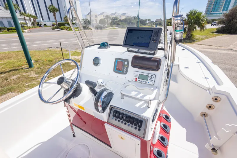 Slide: The Image of 2003 Triton 220 LTS boat console with steering wheel, navigation equipment, and control panel. - 29