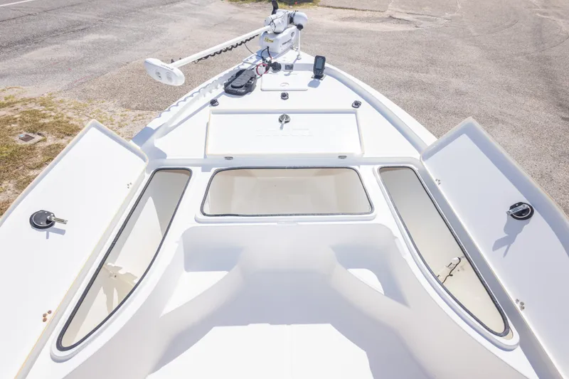 Slide: The Image of 2003 Triton 220 LTS boat deck with open storage compartments and trolling motor. - 33
