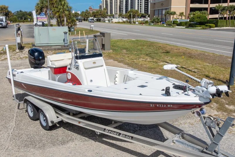 Slide: The Image of 2003 Triton 220 LTS boat on trailer, parked near road with palm trees. - 1