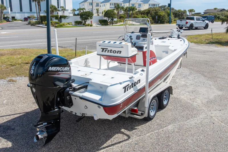 Slide: The Image of 2003 Triton 220 LTS boat with Mercury engine on trailer, parked near coastal road. - 50