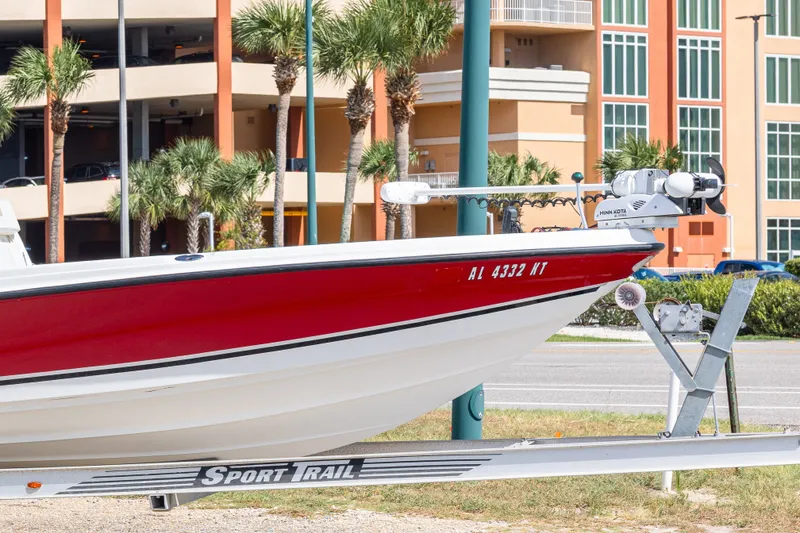 Slide: The Image of 2003 Triton 220 LTS boat on trailer, red and white, parked near palm trees. - 11