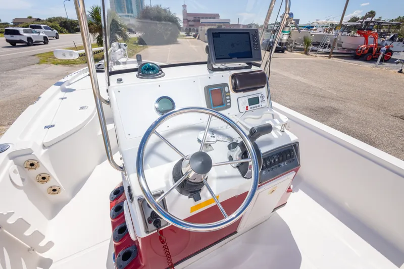 Slide: The Image of 2003 Triton 220 LTS boat console with steering wheel and navigation equipment. - 28
