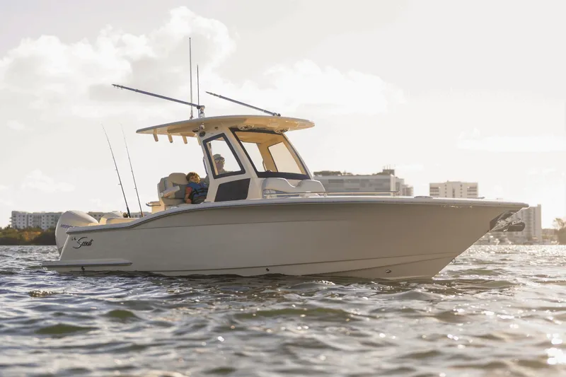 Slide: The Image of 2027 Scout 260 LXF on the water with an urban backdrop. - 9