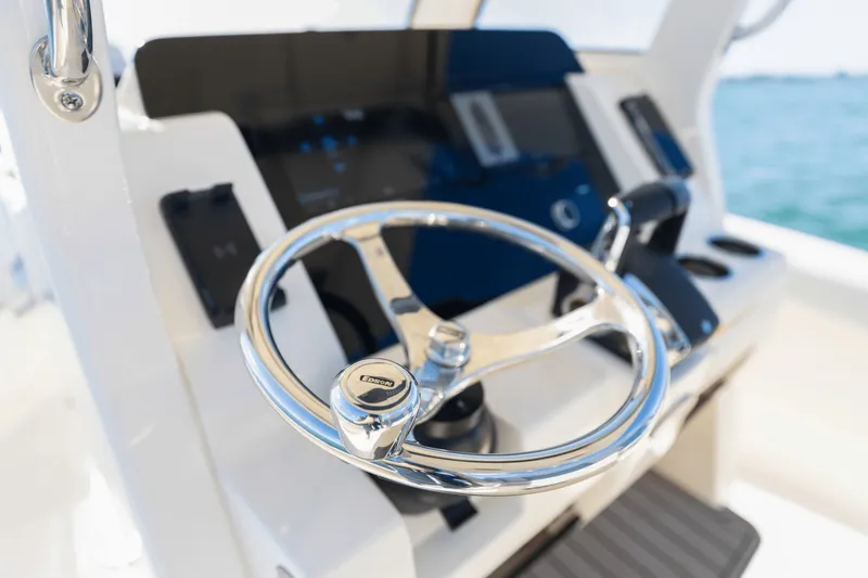 Slide: The Image of The image shows the helm of a Scout 260 LXF boat with a shiny wheel and modern instruments. - 28
