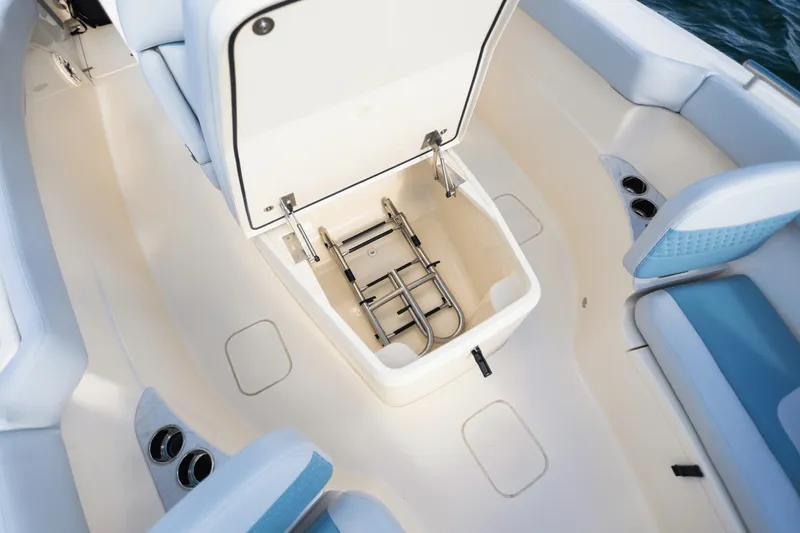 Slide: The Image of An open storage compartment on a boat with a ladder inside, surrounded by blue upholstery. - 25
