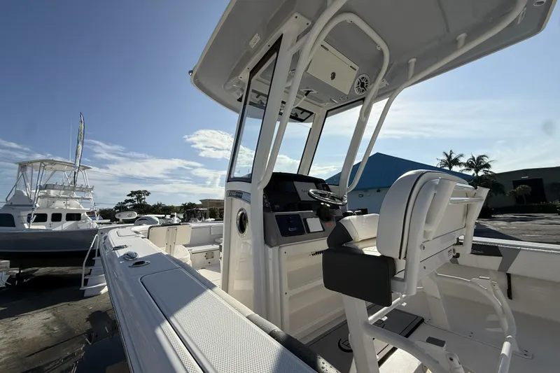 Slide: The Image of 2023 Robalo 266 Cayman boat interior with helm and seating under clear sky. - 10