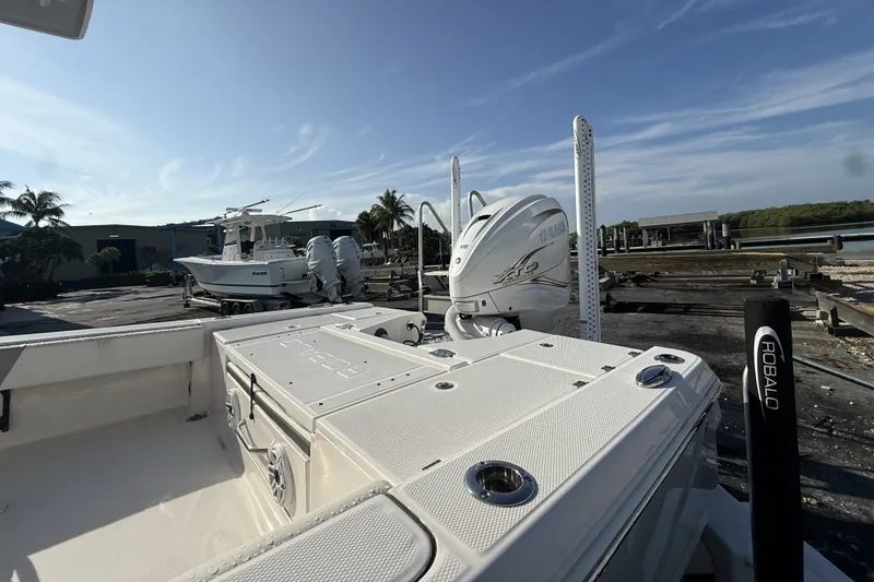 Slide: The Image of 2023 Robalo 266 Cayman boat with Yamaha engine, docked under clear blue sky. - 11