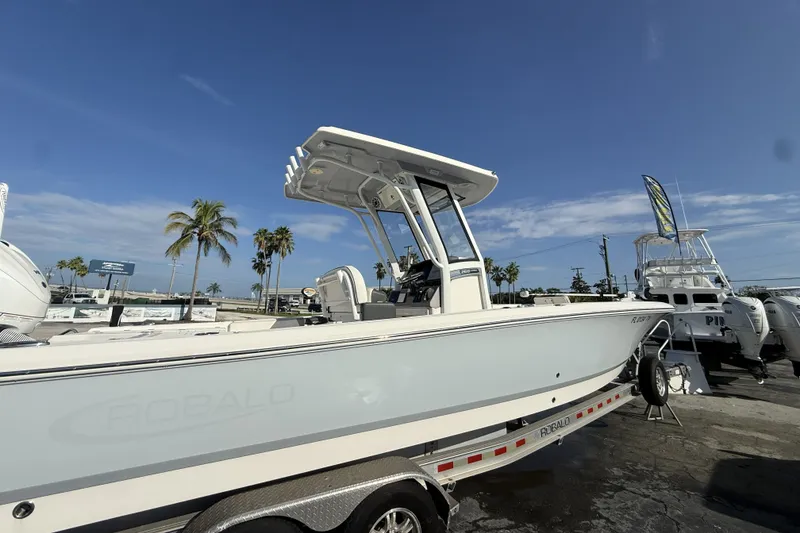 Slide: The Image of 2023 Robalo 266 Cayman boat on trailer under clear blue sky. - 7