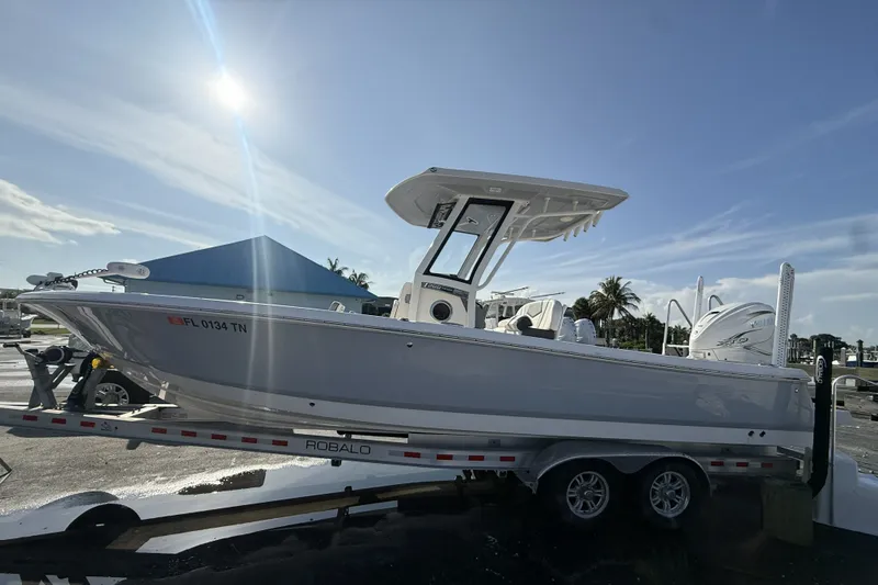 Slide: The Image of 2023 Robalo 266 Cayman boat on trailer under sunny sky. - 5