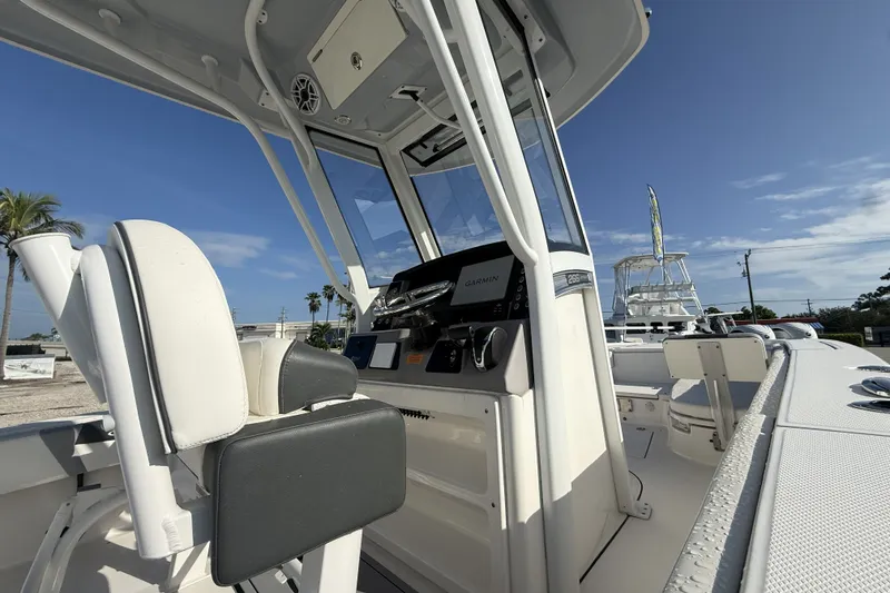 Slide: The Image of 2023 Robalo 266 Cayman boat interior with helm and seating under clear blue sky. - 14