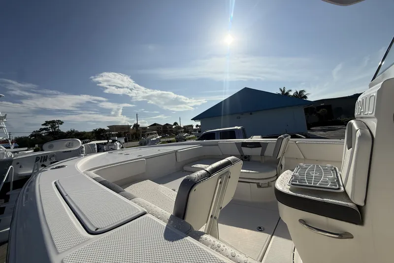 Slide: The Image of 2023 Robalo 266 Cayman boat interior under sunny sky, showcasing seating and deck features. - 9