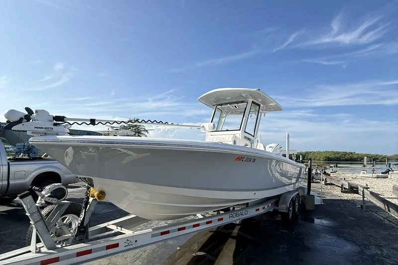 Slide: The Image of 2023 Robalo 266 Cayman boat on trailer under clear blue sky. - 2